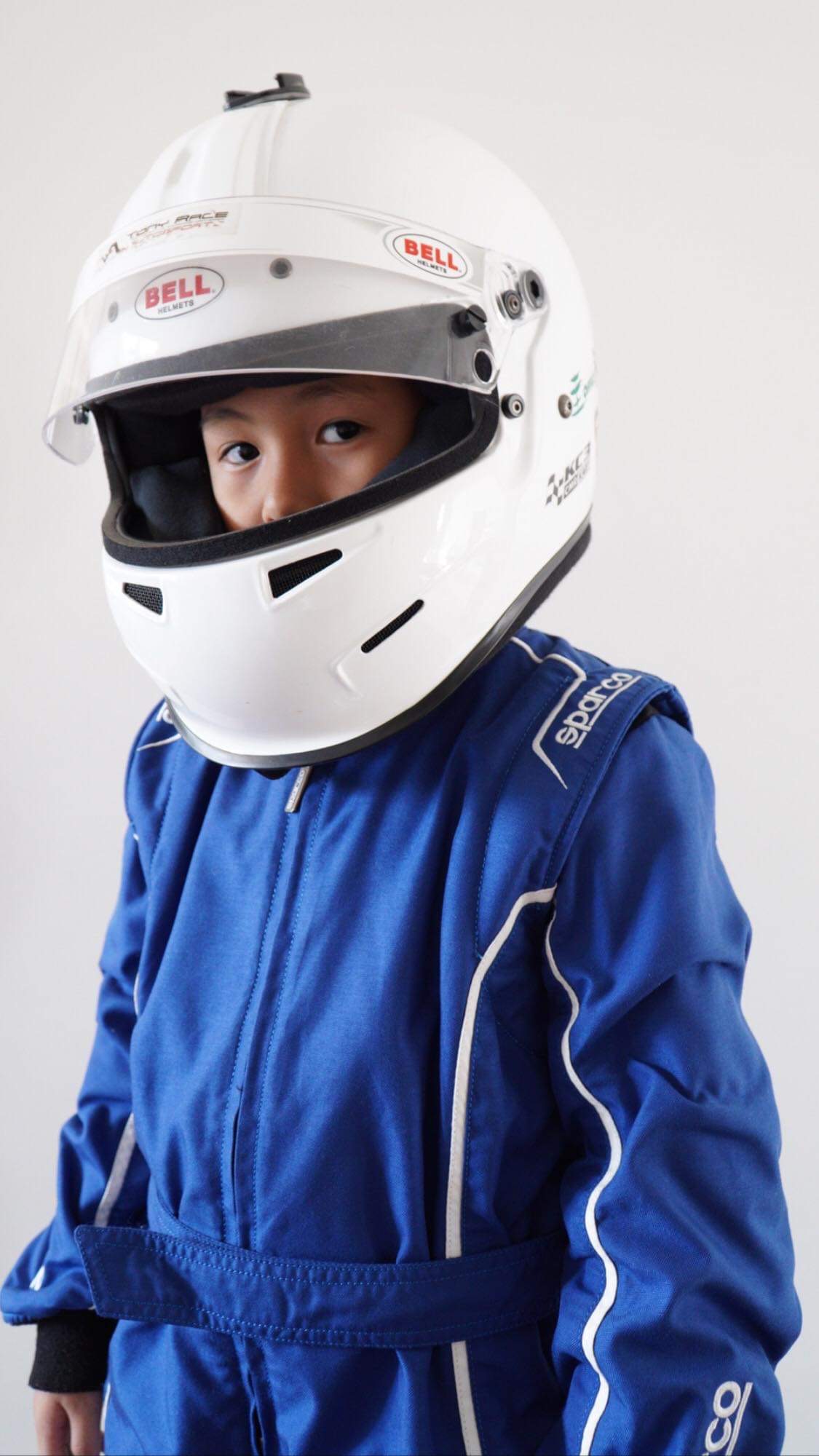 Young Antonio Racelis wearing his first racing suit and helmet