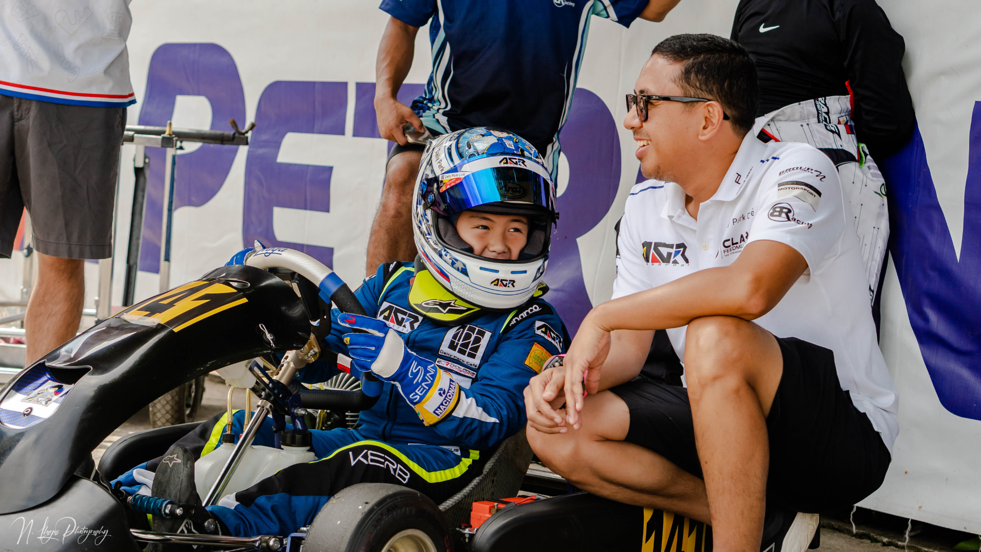 Antonio Racelis seated in his kart with his father