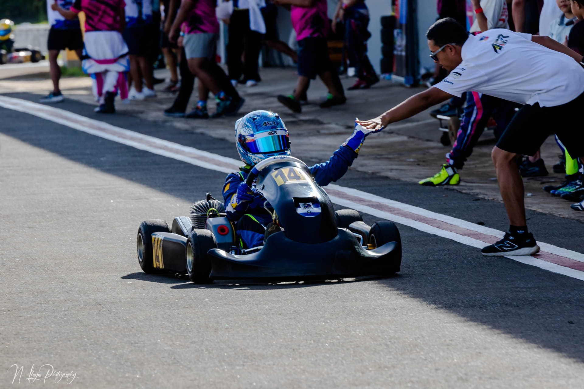 Antonio Racelis high-fiving a team member from his kart