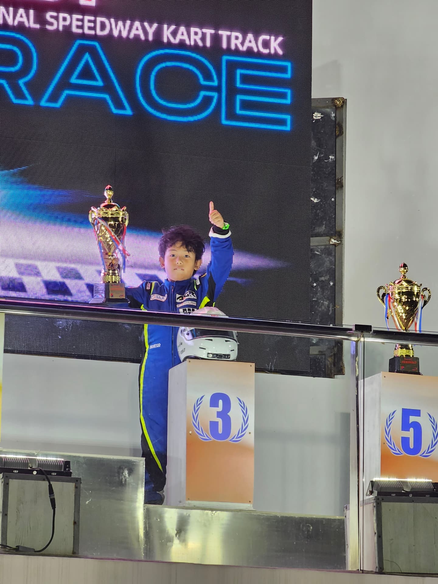 Antonio Racelis holding a trophy on the third-place podium