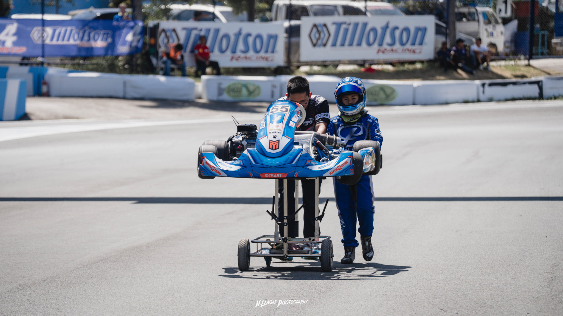 Antonio Racelis and a team member wheeling his kart