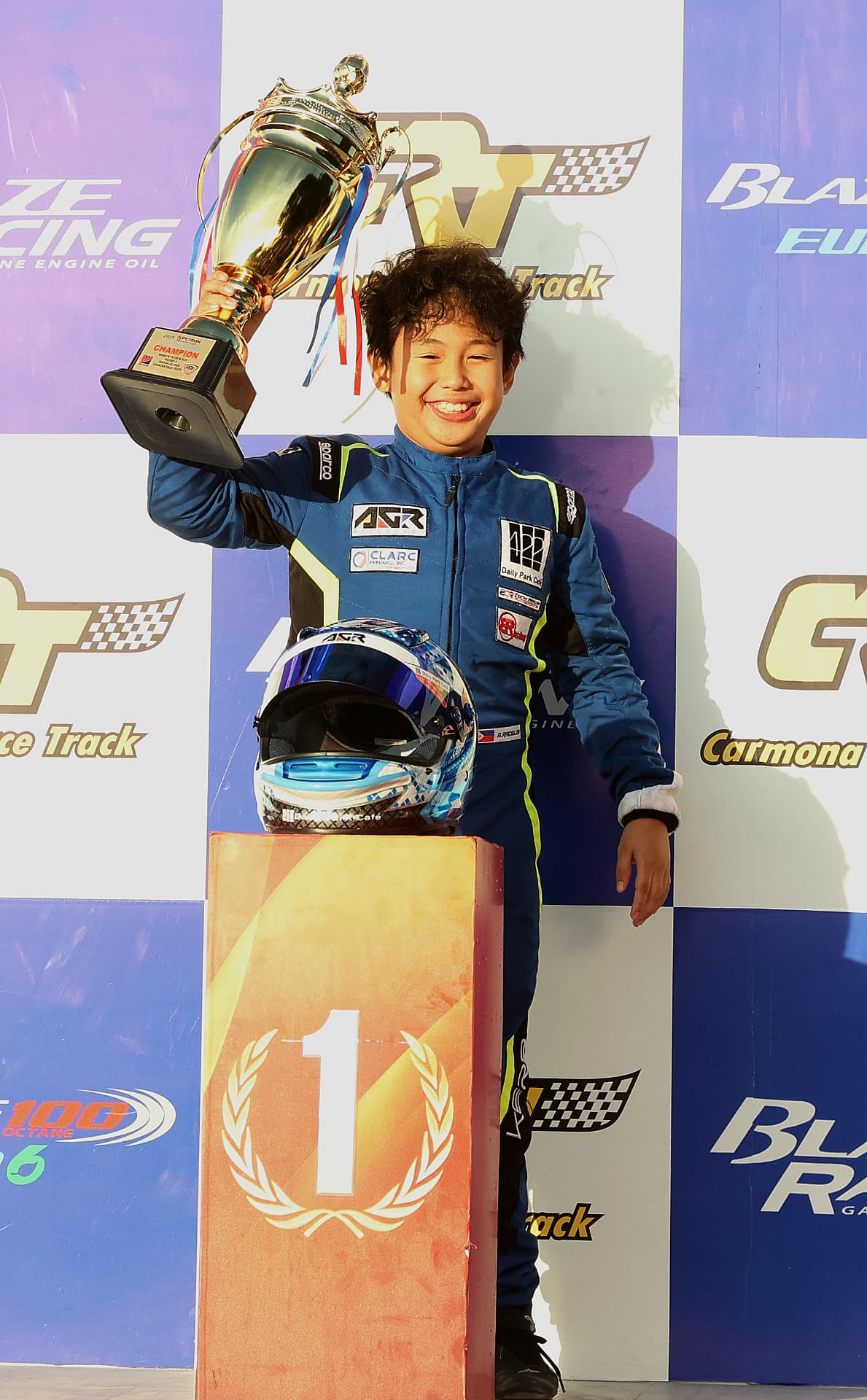 Antonio Racelis lifting the champion's trophy on the top step of the podium