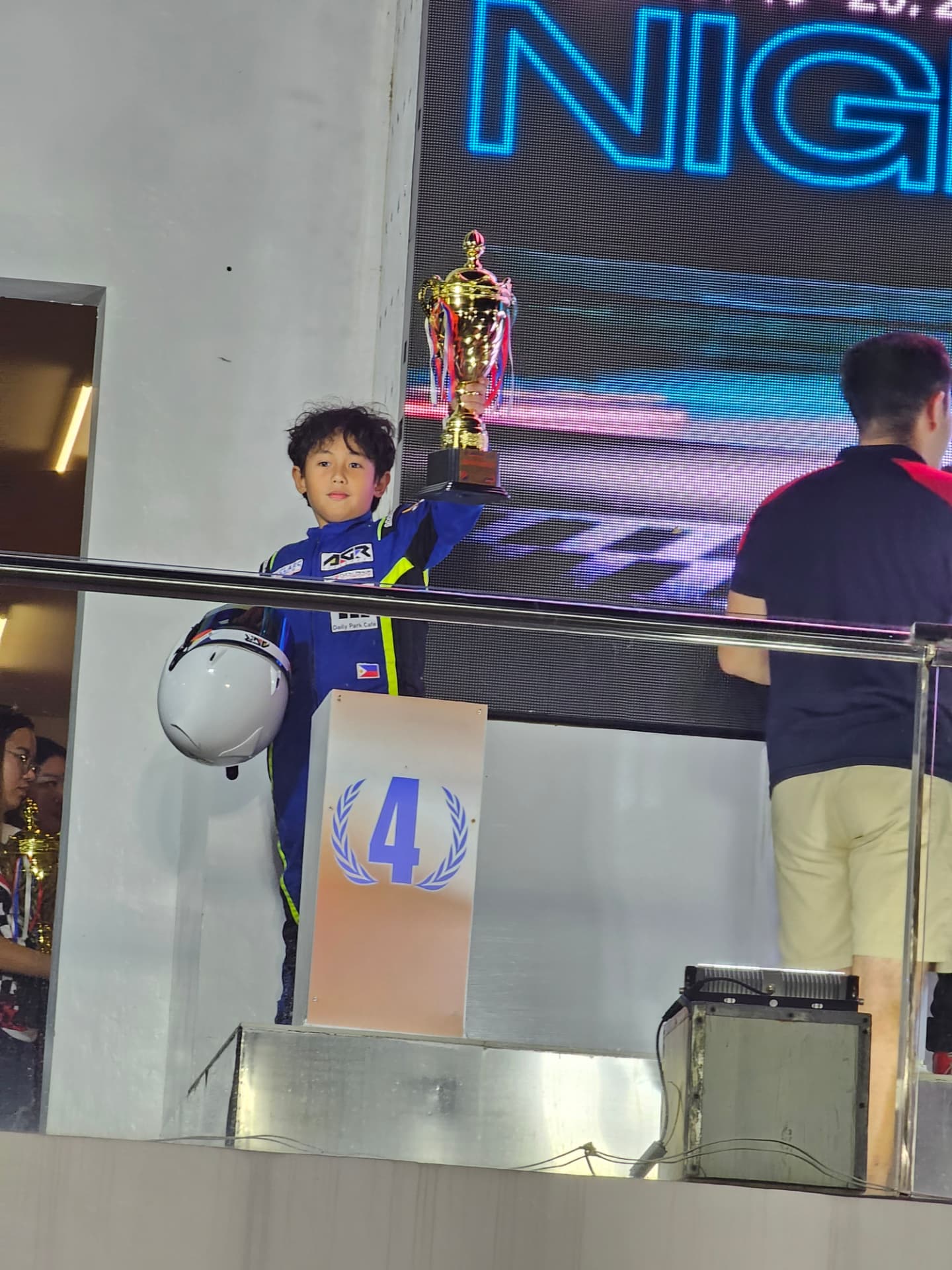 Antonio Racelis holding a trophy on the podium