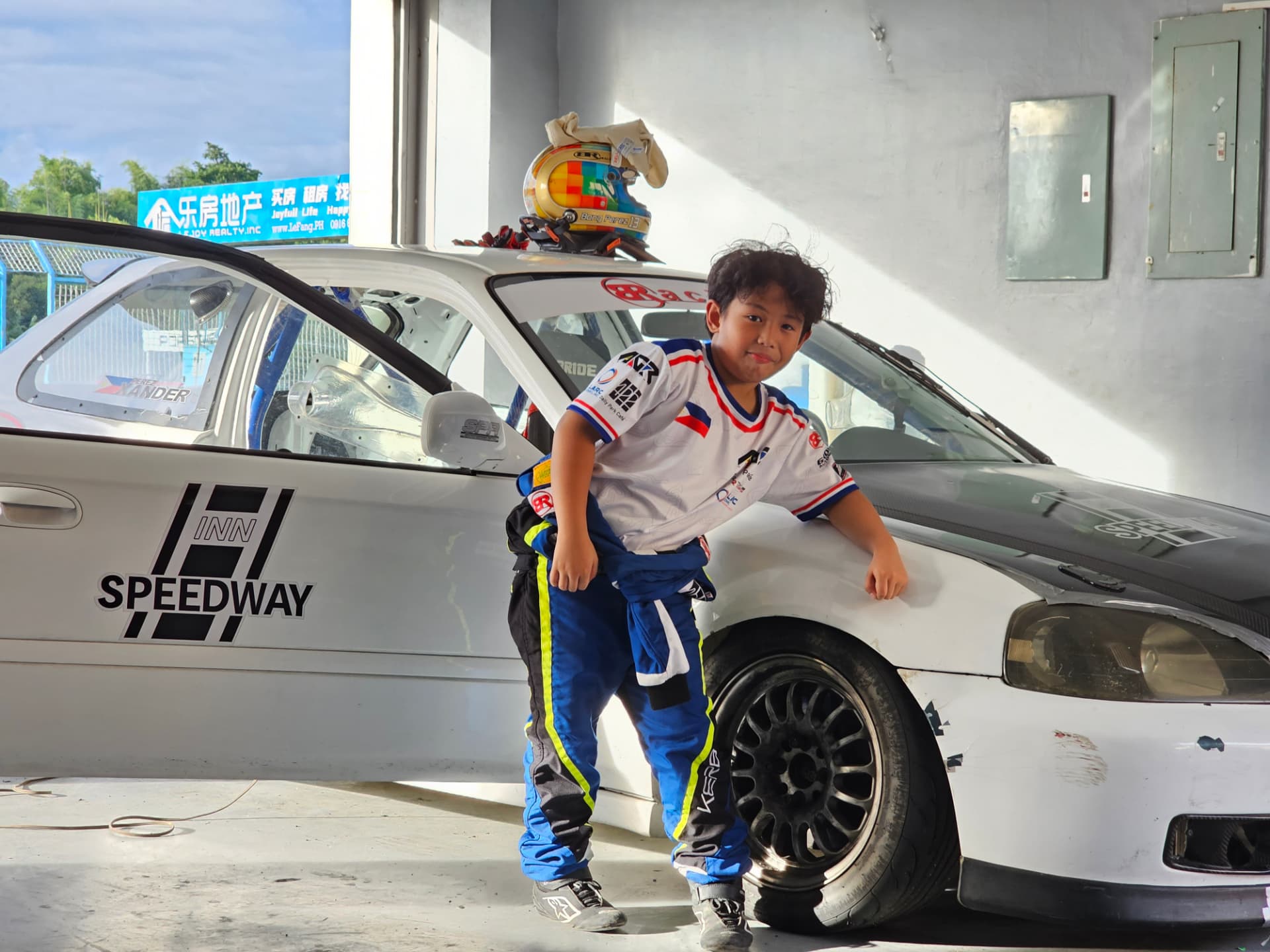 Antonio Racelis next to a race car