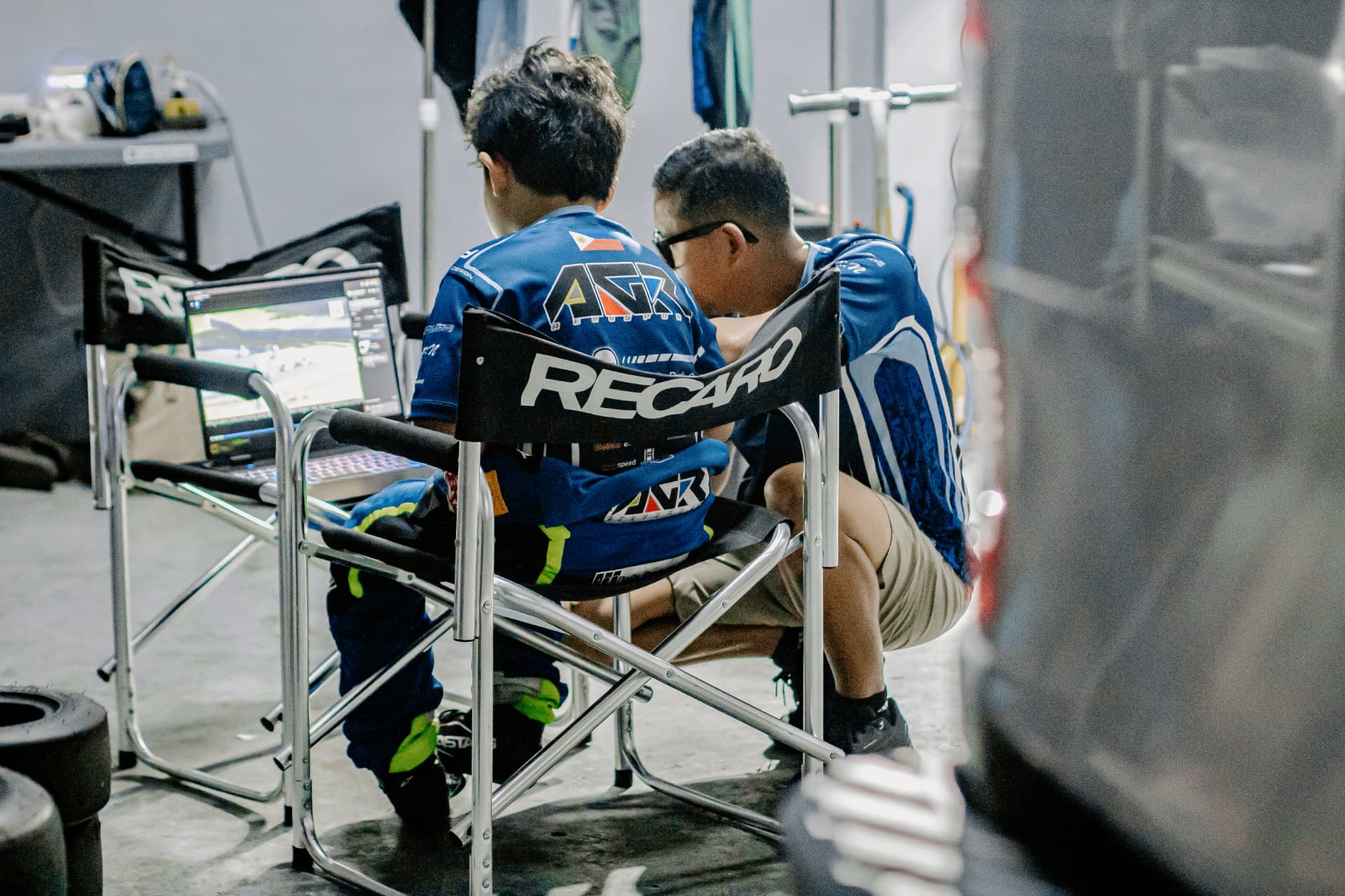 Antonio Racelis and a team member looking at a screen in the paddock