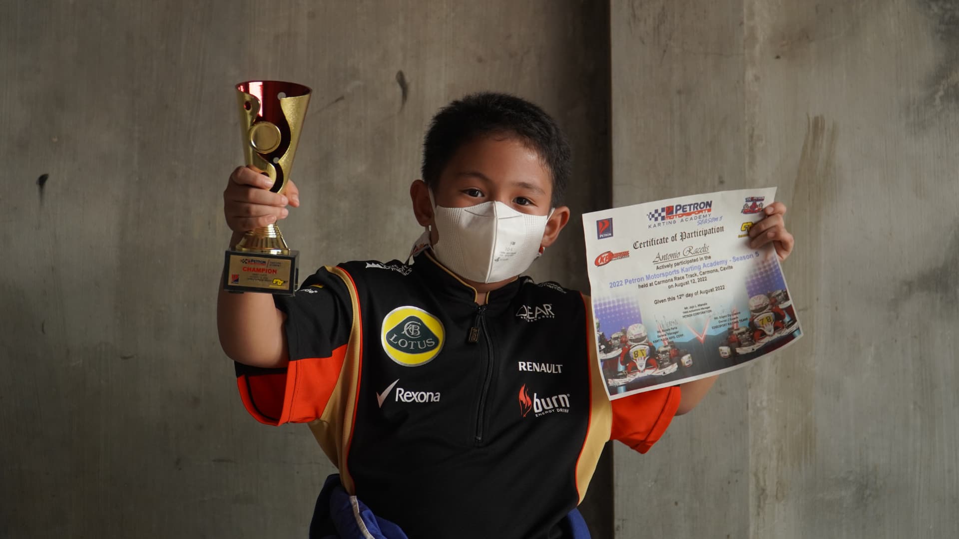 Antonio Racelis holding a trophy and certificate
