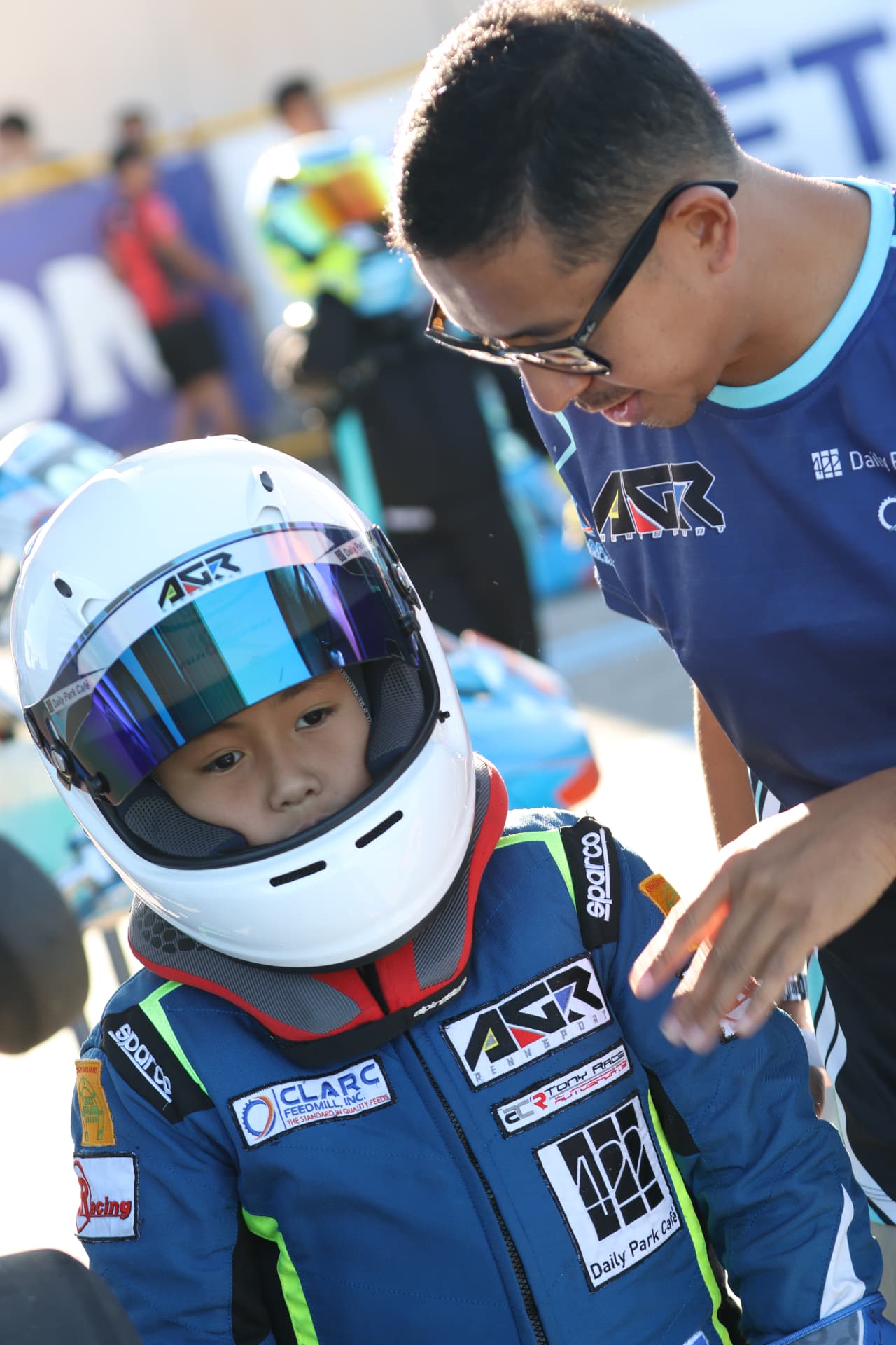 Young Antonio Racelis wearing his helmet beside his father