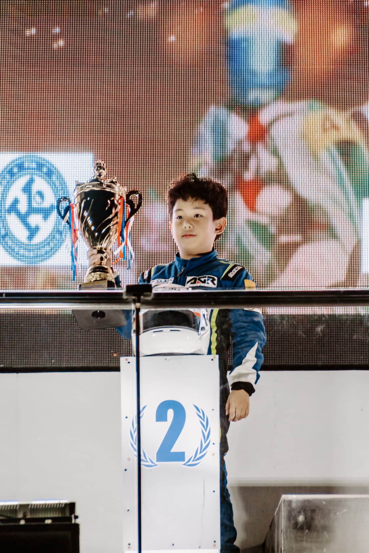 Antonio Racelis holding a trophy on the second-place podium