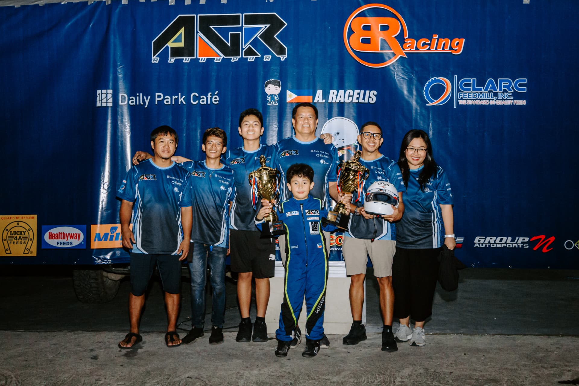 Antonio Racelis holding trophies with his team